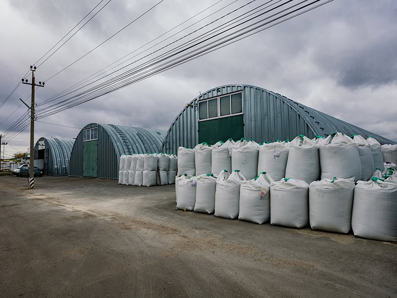 Industrial warehouses with round roof and plastic bags with goods.